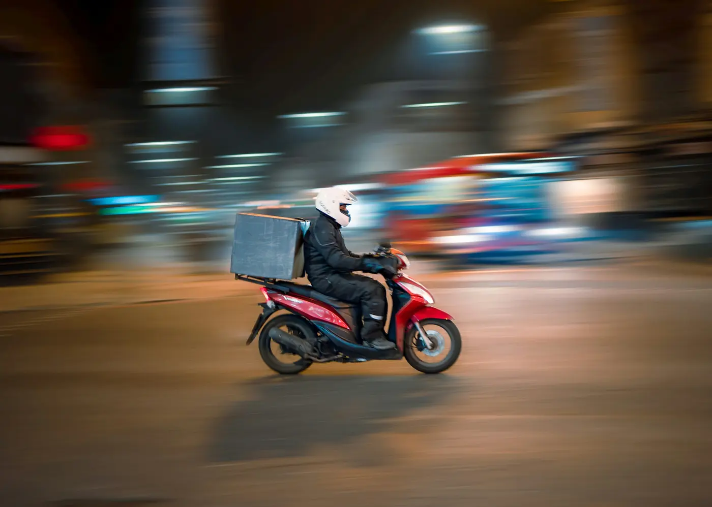 A delivery driver on a red scooter