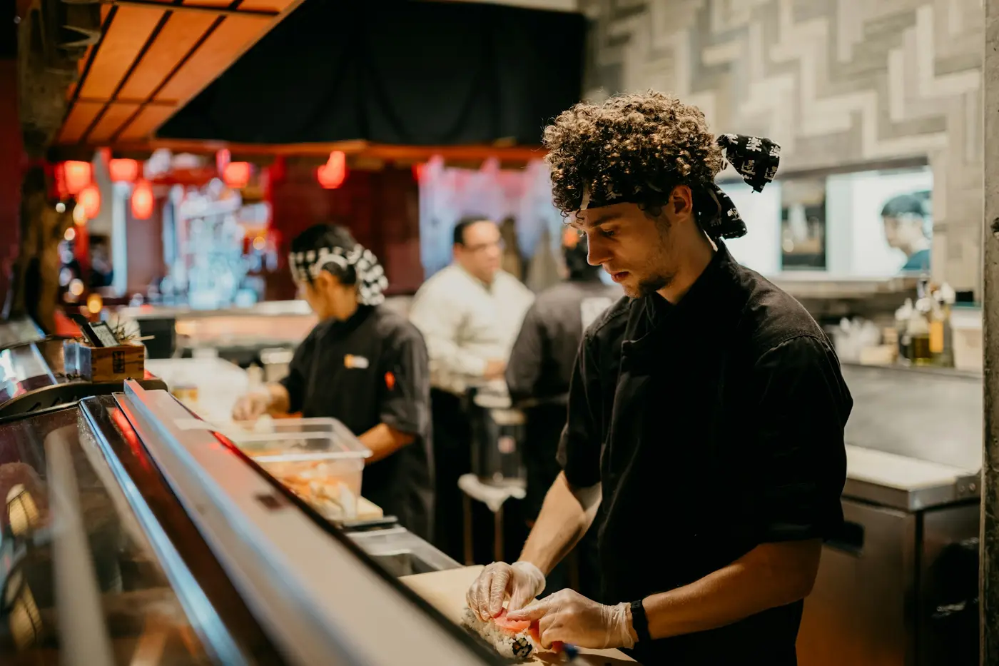 Cooks preparing food on the line in a busy restaurant kitchen
