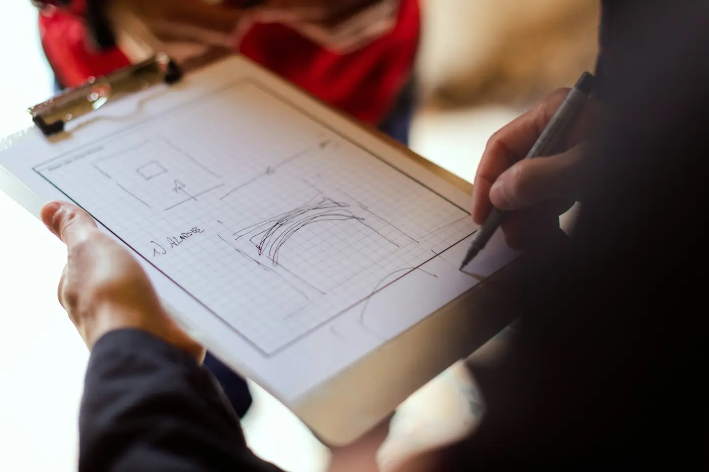 A person writing notes on a clipboard with a floor plan