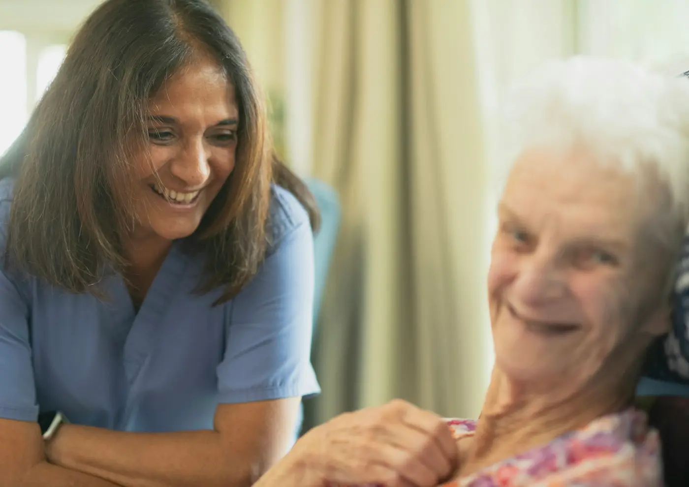 A nurse smiling with an older patient